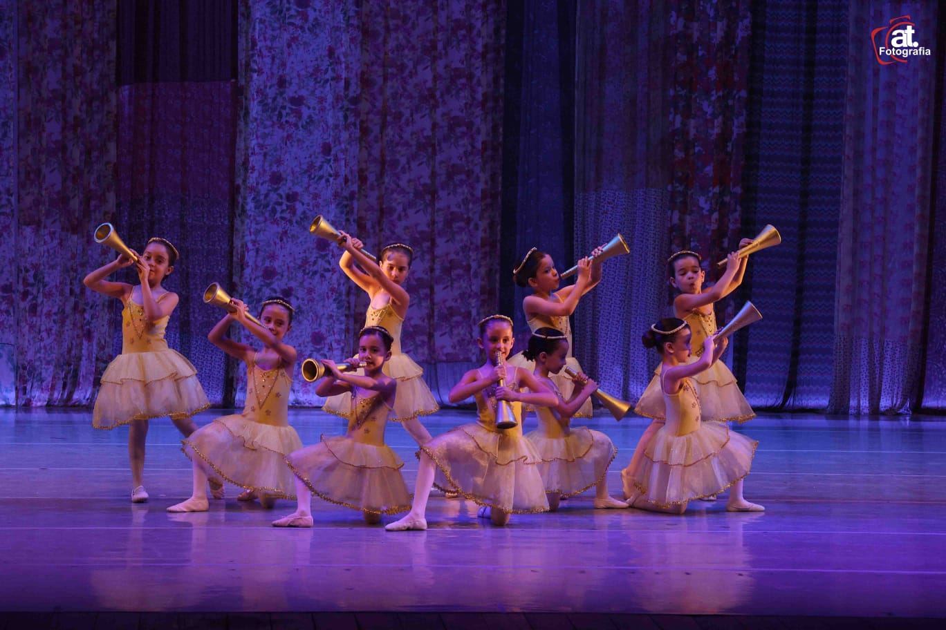 Bailarinas com figurino dourado em cena no palco do espetáculo